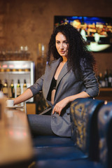Elegant lady in a business suit, in a restaurant at a bar counter alone
