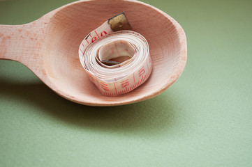 Measuring tape on a spoon. Healthy lifestyle. Lose weight by the summer. Proper nutrition. Diet.	
