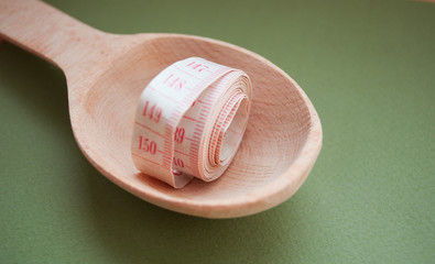 Tape measure on a wooden spoon. Healthy lifestyle. Lose Weight By Summer. Proper nutrition. Diet.