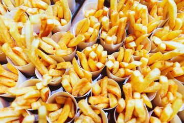 French fries in paper cups. Catering and guest meals during the event. Quick mini snacks in a special beautiful dish. Canapes and light meals, tapas on the table in the restaurant.