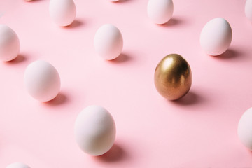 White chicken eggs nicely arranged in creative pattern on pastel pink background. Creative Ester holiday concept.