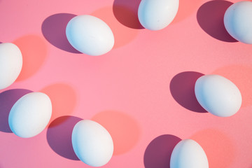 Natural white eggs on pastel pink background flat lay
