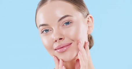 Close up of beauty woman face looking at camera, isolated on blue background. Beautiful female model with perfect clean fresh skin. Skin care treatment or cosmetic ads concept - Powered by Adobe