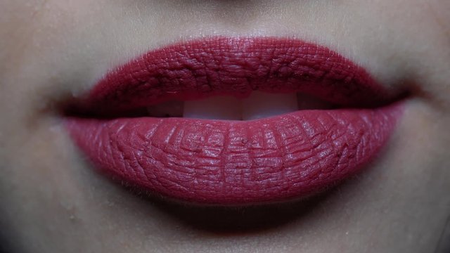 extreme close-up woman's lips blowing a kiss and smiling
