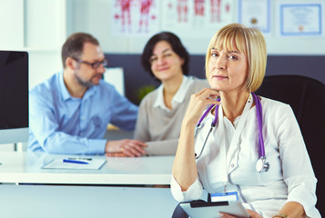 Fototapeta premium Doctor woman sitting with male patient at the desk