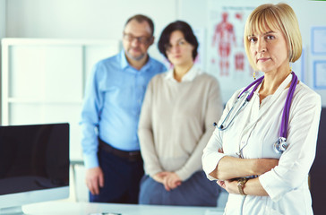 Fototapeta premium Smiling medical doctor with stethoscope and elderly couple