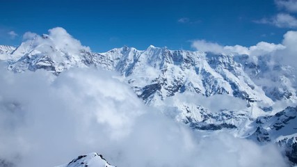 Time Lapse of a snow covered mountain peaks in the Swiss Alps with clouds blowing past.