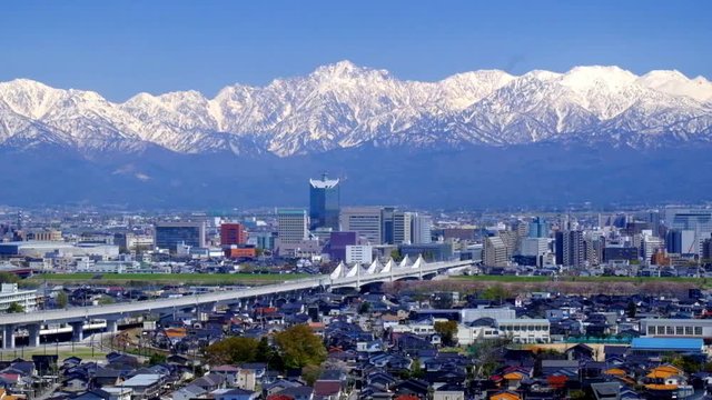 北陸新幹線上り下り冬の富山市街地と冠雪の北アルプス