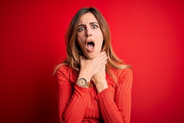 Young beautiful brunette woman wearing casual turtleneck sweater over red background shouting suffocate because painful strangle. Health problem. Asphyxiate and suicide concept.