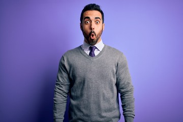 Handsome businessman with beard wearing casual tie standing over purple background afraid and shocked with surprise expression, fear and excited face.