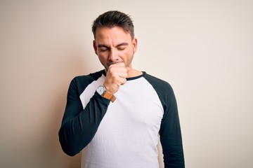 Young handsome man wearing casual t-shirt standing over isolated white background feeling unwell and coughing as symptom for cold or bronchitis. Health care concept.