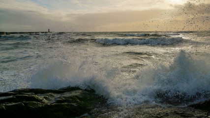 Colorful dramatic seascape with dark clouds and sun beams. Ocean surf.