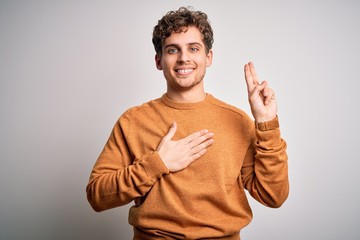 Young blond handsome man with curly hair wearing casual sweater over white background smiling...