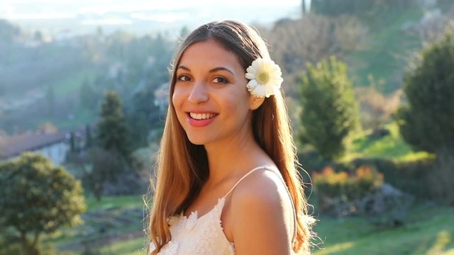 Beautiful smiling young Brazilian woman. Pretty face turn to the camera with nature on background. Happy sweet girl close up front portrait. Slow motion.