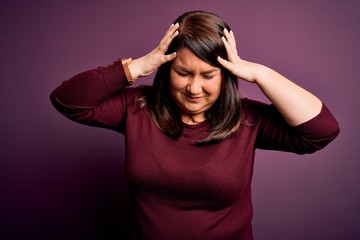 Beautiful brunette plus size woman wearing casual sweater over isolated purple background suffering...