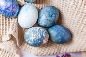Obraz premium Easter atmosphere. Dyed Easter eggs and spring flowers on a white background. Easter atmosphere.