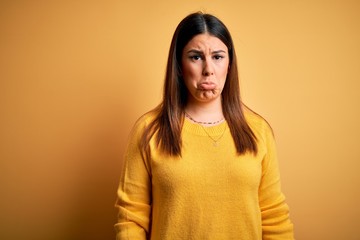 Young beautiful woman wearing casual sweater over yellow isolated background depressed and worry for distress, crying angry and afraid. Sad expression.