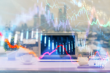 Forex graph hologram on table with computer background. Multi exposure. Concept of financial...