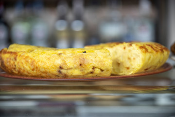 Tasty Spanish omelette with freshly made potatoes Skewer exposed in the bar of a bar on a plate at the counter as a culinary delicacy for customer consumption