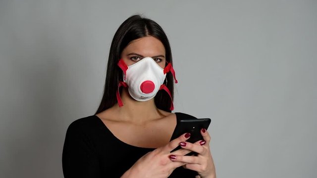 ragazza con maschera ffp3 chatta con telefono