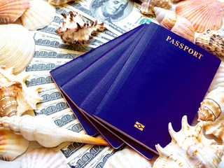 Four passports on a fan of hundred-dollar bills