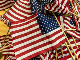 a stack of mini American Flags are stacked as they are prepared to be placed at the National Cemetery
