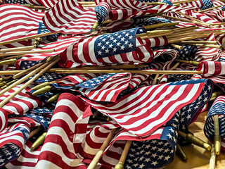 a stack of mini American Flags are stacked as they are prepared to be placed at the National Cemetery