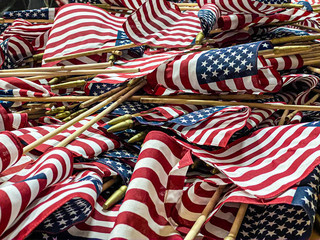 a stack of mini American Flags are stacked as they are prepared to be placed at the National Cemetery