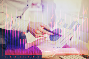 Financial trading graph double exposure with man desktop background.