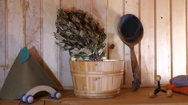Interior wooden empty traditional Russian Sauna. Spa room Relaxation. Bath accesories massage, towels, hat, bucket, broom, ladle.