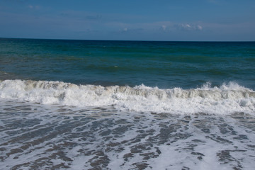 Mediterranean sea at sunset. Waves break on the sandy shore, sea foam. Natural background