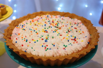 Chocolate pie with cream, sparkling dots, whipped cream and sugar colorful candy. Handmade candy. Special dessert served at a kids party