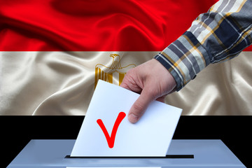 Fototapeta na wymiar male hand of a voter lowers the ballot in the ballot box against the background of the national flag of yemen country, concept of state election