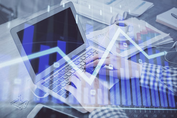 Double exposure of forex graph with man working on computer on background. Concept of market...