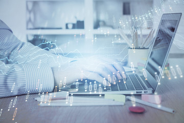 Double exposure of stock market graph with man working on laptop on background. Concept of financial analysis.