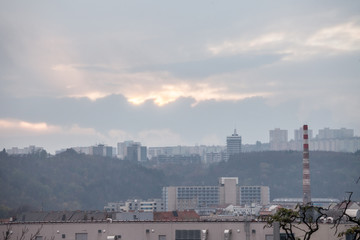 Obraz premium Panorama of Czech brutalist buildings, called Panelaky, in the suburbs of Brno, Czechia, with old industrial buildings with a factory chimney. They are symbols of communist architecture