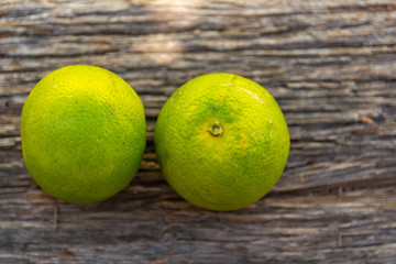 Fresh green oranges on an aged wooden background