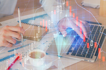 Forex graph with businessman working on computer in office on background. Concept of hardworking. Double exposure.