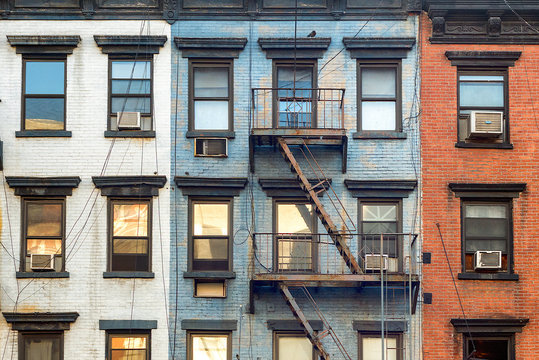 Red, white and blue facade of pre-war residential building in urban New York City