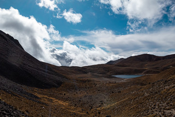 Fototapeta na wymiar Paisaje volcánico de montañas, nubes y laguna