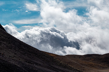 Paisaje montaña y volcán con cielo azul y nubes