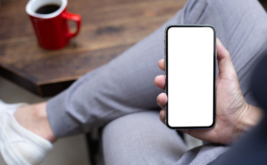 Mockup image blank white screen cell phone.man hand holding texting using mobile on desk at coffee shop.background empty space for advertise text.people contact marketing business,technology