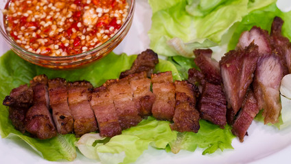 Thai roasted crispy pork on lettuce with Thai Spicy Sauce, Close up view