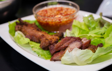 Thai roasted crispy pork on lettuce with Thai Spicy Sauce, Close up view