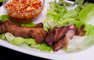 Thai roasted crispy pork on lettuce with Thai Spicy Sauce, Close up view
