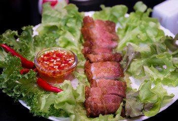 Thai roasted crispy pork on lettuce with Thai Spicy Sauce, Close up view