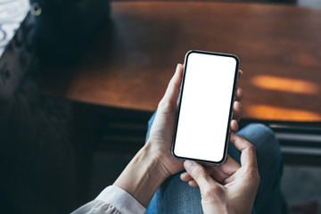Mockup image blank white screen cell phone.woman hand holding texting using mobile on desk at coffee shop.background empty space for advertise text.people contact marketing business,technology