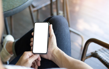 Mockup image blank white screen cell phone.man hand holding texting using mobile on desk at coffee shop.background empty space for advertise text.people contact marketing business,technology