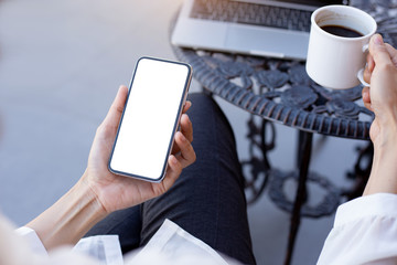 Mockup image blank white screen cell phone.woman hand holding texting using mobile on desk at coffee shop.background empty space for advertise text.people contact marketing business,technology