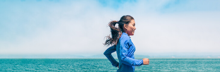 Running woman jogging on ocean beach background training for triathlon race outdoor summer workout banner panorama.